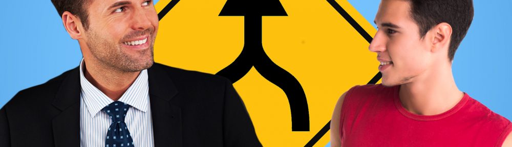 Middle-aged man in suit with younger guy in t-shirt in front of a merge sign