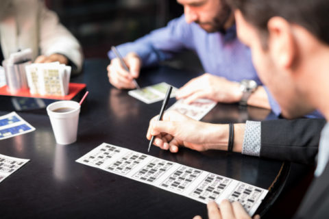 Point of view of a young man crossing some numbers while playing casino lottery