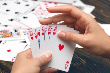 Well-conditioned female hands holding playing cards with poker strongest combination - royal flush