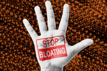 An open hand with Stop Bloating written on the palm